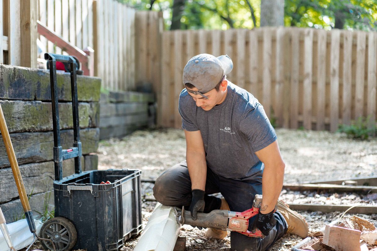 Man cutting materials for Atlanta waterproofing company