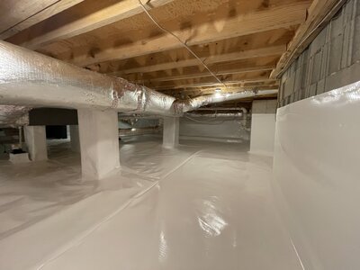 Man knelt down cutting materials for crawlspace encapsulation in Atlanta